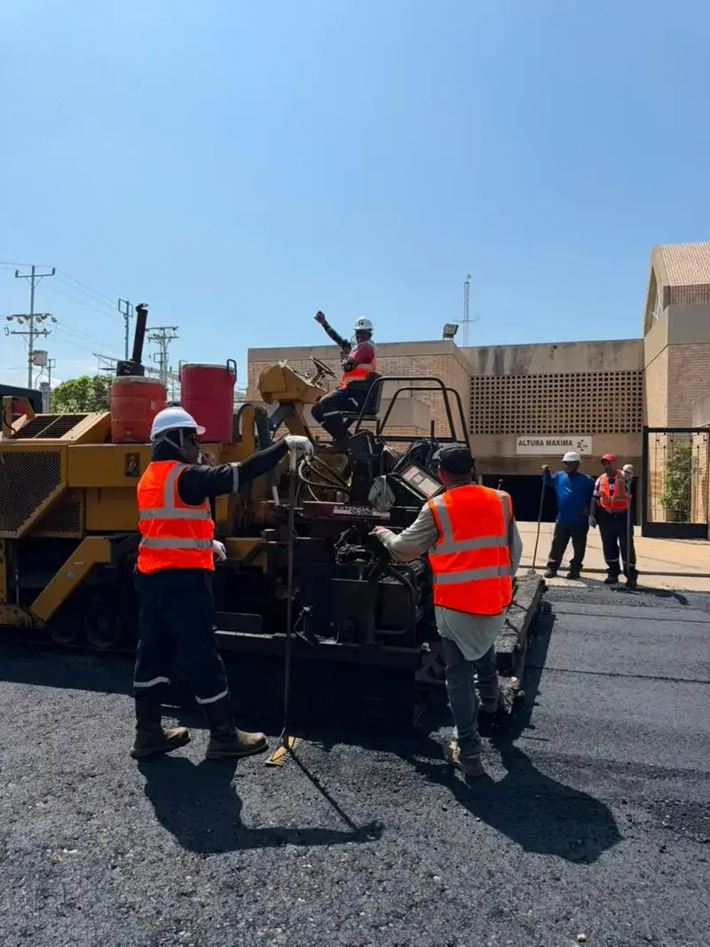 Operadores con equipo de protección personal trabajando sobre la terminadora